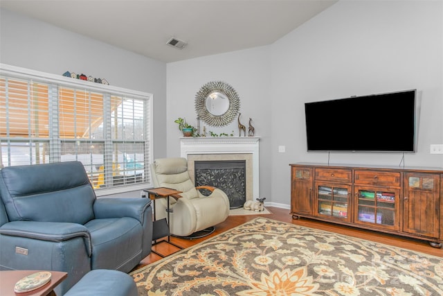 living room with hardwood / wood-style floors and a high end fireplace