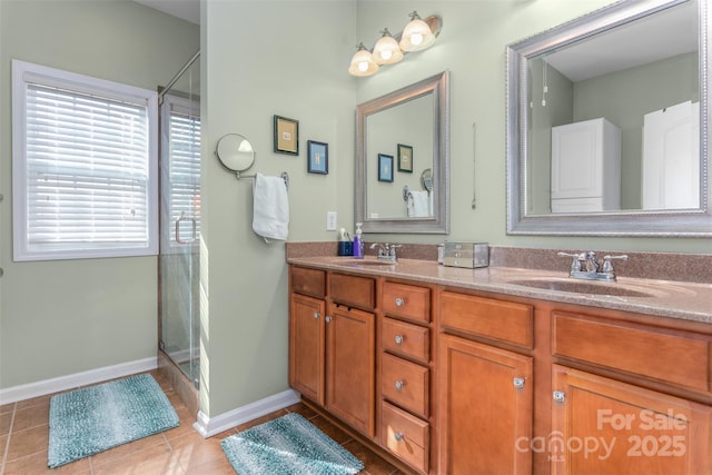 bathroom with a shower with door, vanity, and tile patterned floors