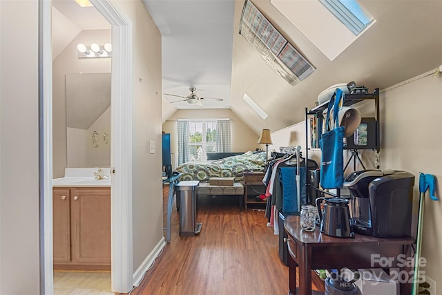 bedroom with sink, hardwood / wood-style flooring, and lofted ceiling with skylight