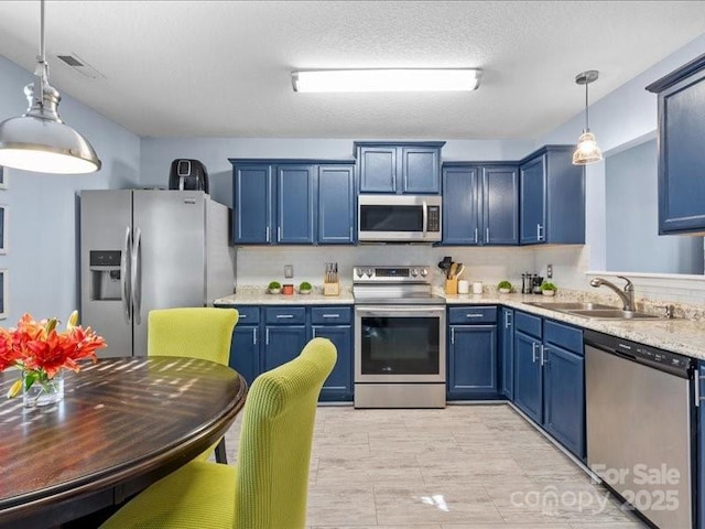 kitchen featuring blue cabinets, sink, decorative light fixtures, and appliances with stainless steel finishes