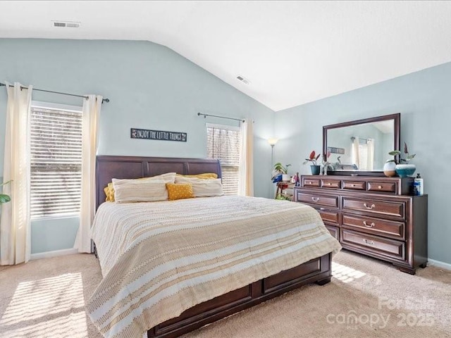 bedroom with light colored carpet, lofted ceiling, and multiple windows