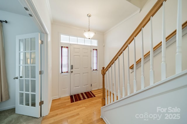 foyer featuring crown molding and light hardwood / wood-style floors