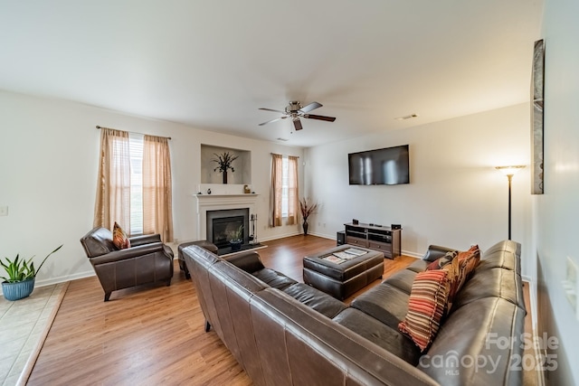 living room with ceiling fan, light wood-type flooring, and a wealth of natural light