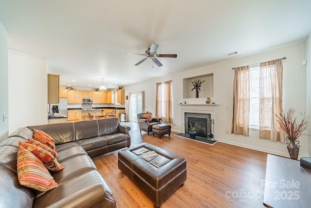 living room featuring ceiling fan and light hardwood / wood-style floors