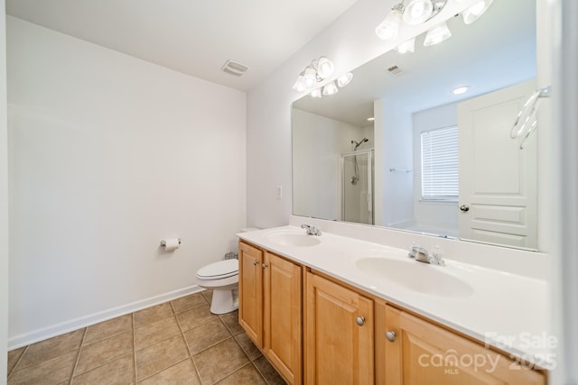 bathroom featuring tile patterned floors, toilet, a shower with shower door, and vanity