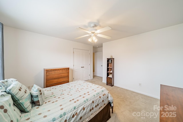 bedroom featuring light carpet, ceiling fan, and a closet