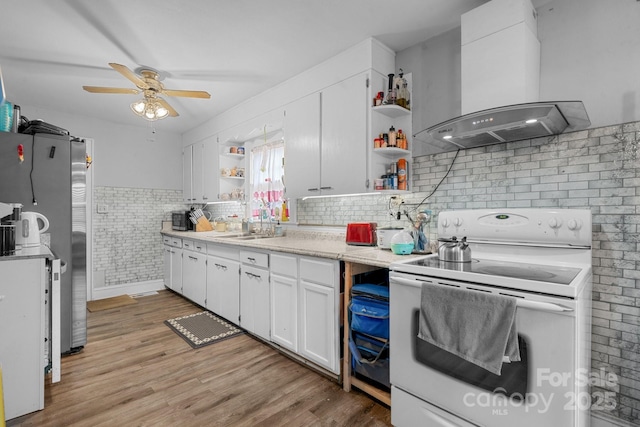 kitchen with white cabinets, electric range, light hardwood / wood-style flooring, and wall chimney exhaust hood