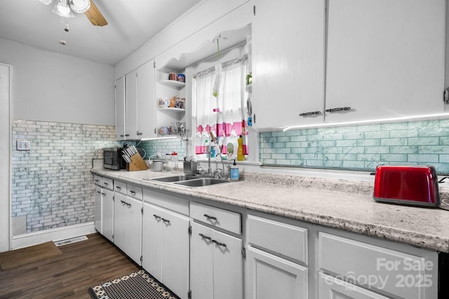 kitchen with white cabinetry, dark wood-type flooring, sink, and ceiling fan