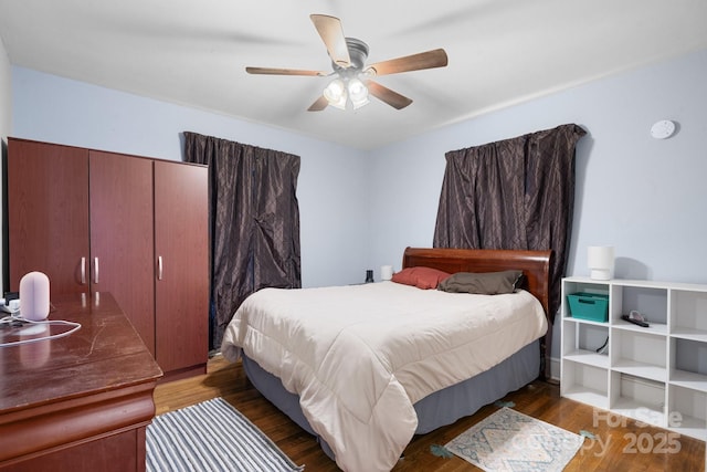 bedroom with dark hardwood / wood-style floors and ceiling fan