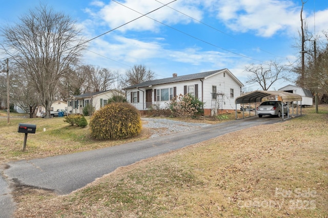 view of front facade featuring a front lawn and a carport