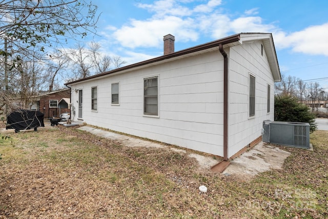 view of property exterior featuring a lawn and central air condition unit