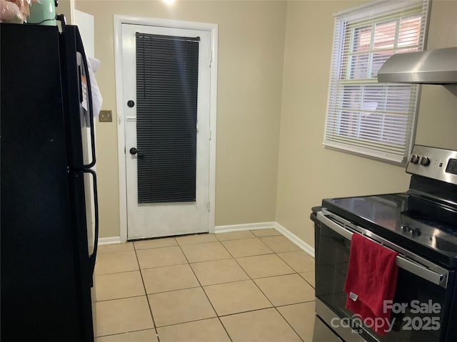 kitchen with extractor fan, black refrigerator, light tile patterned flooring, and stainless steel electric range