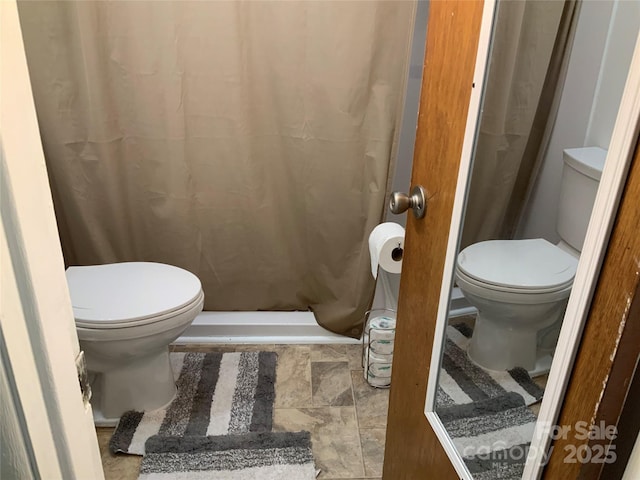 bathroom with a shower with curtain and toilet