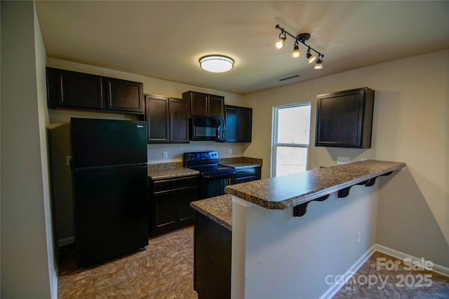 kitchen with dark brown cabinets, black appliances, kitchen peninsula, and a breakfast bar