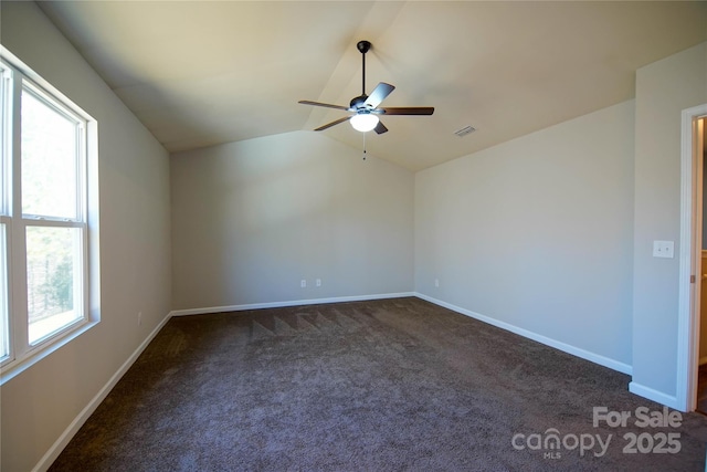 carpeted empty room featuring ceiling fan, a healthy amount of sunlight, and vaulted ceiling