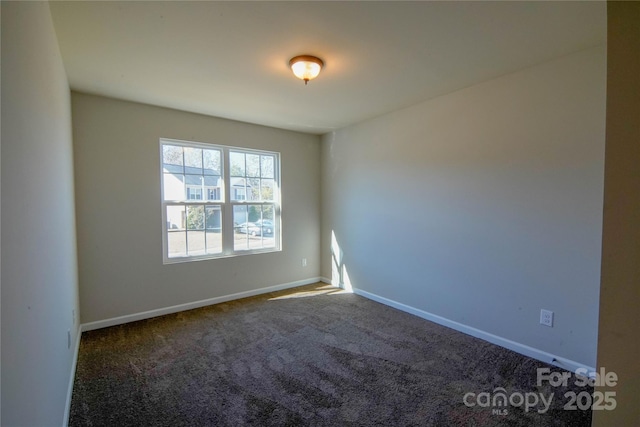 spare room featuring dark colored carpet