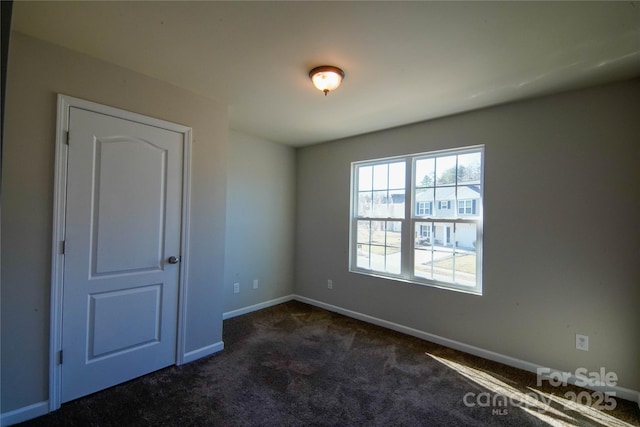 spare room with dark colored carpet