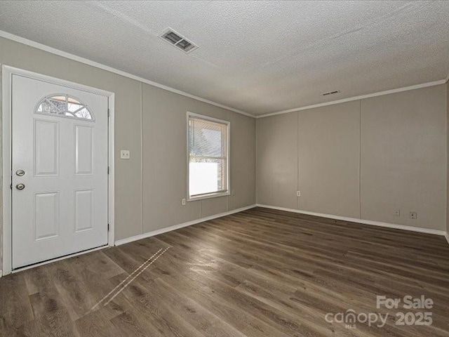 foyer with ornamental molding, dark hardwood / wood-style floors, and a textured ceiling