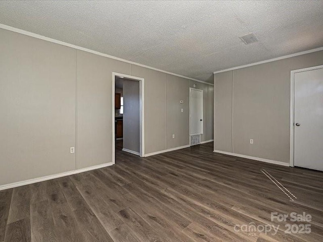 empty room with ornamental molding, dark wood-type flooring, and a textured ceiling