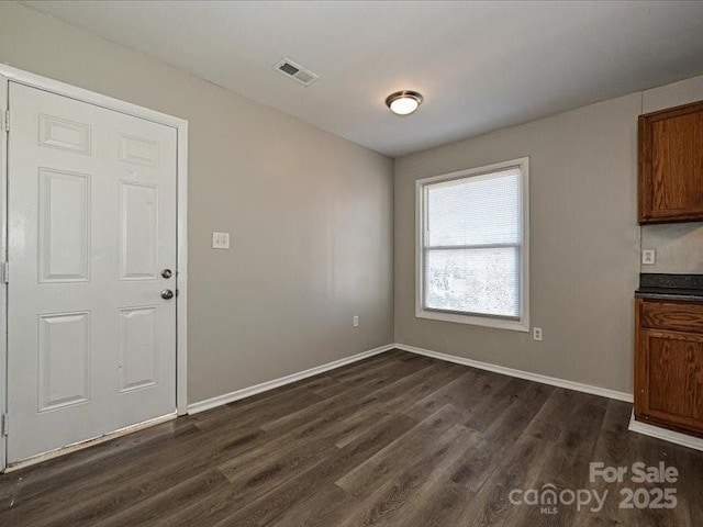 unfurnished dining area featuring dark hardwood / wood-style flooring