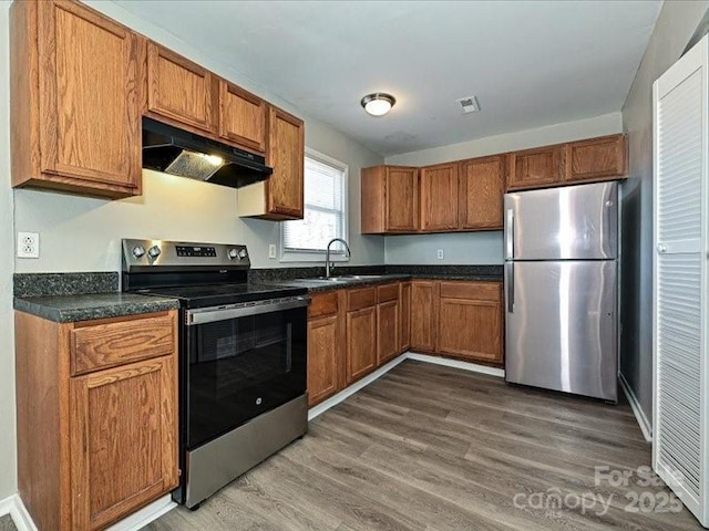 kitchen with appliances with stainless steel finishes, sink, and dark wood-type flooring