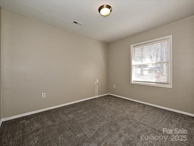 empty room featuring dark colored carpet