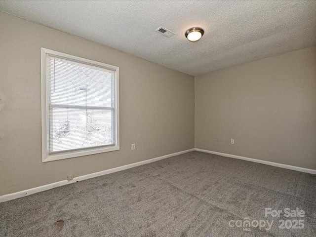 carpeted spare room with a textured ceiling