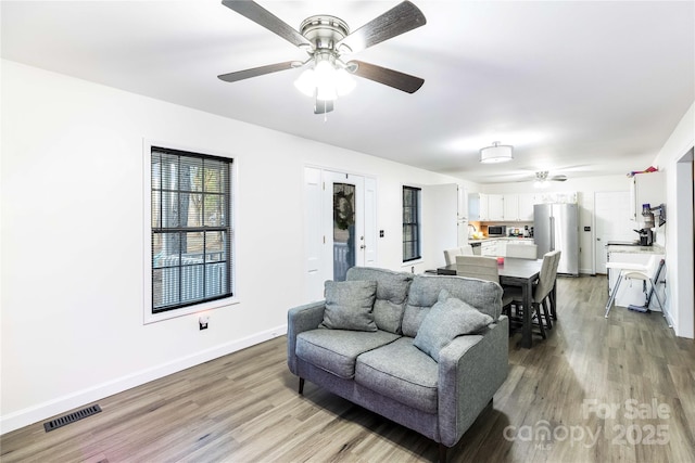 living room with ceiling fan and hardwood / wood-style floors