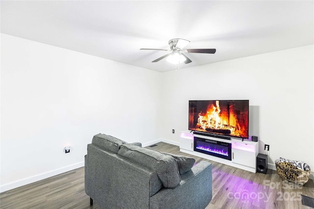 living room featuring hardwood / wood-style floors and ceiling fan