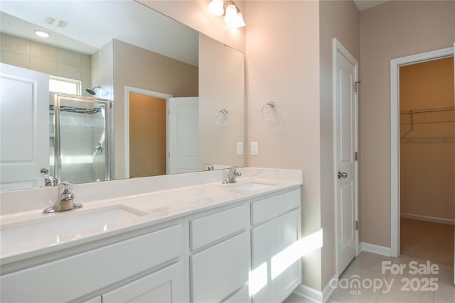 bathroom with an enclosed shower, vanity, and tile patterned floors