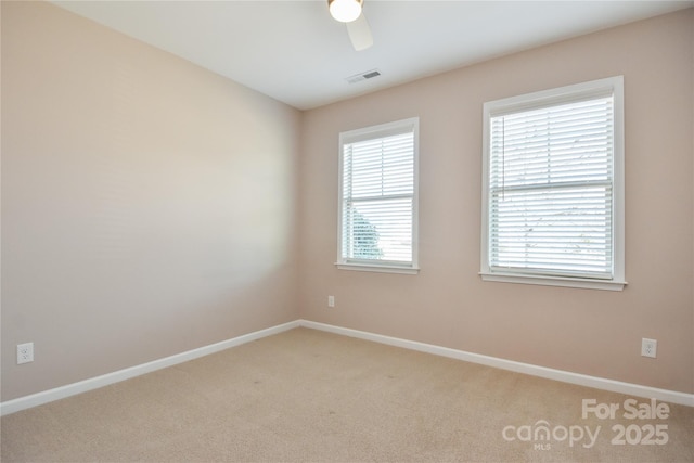 carpeted spare room featuring ceiling fan