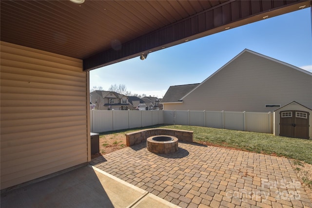 view of patio / terrace with a storage shed and an outdoor fire pit