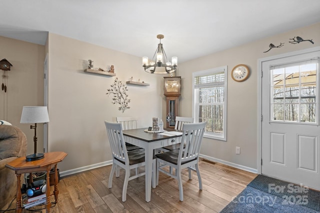 dining room with an inviting chandelier and light hardwood / wood-style flooring