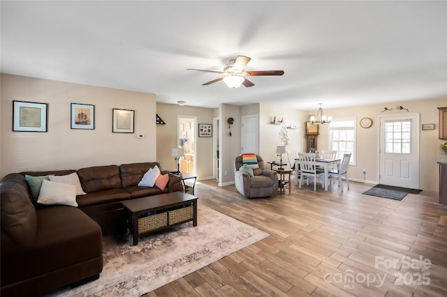 living room with hardwood / wood-style flooring and ceiling fan with notable chandelier