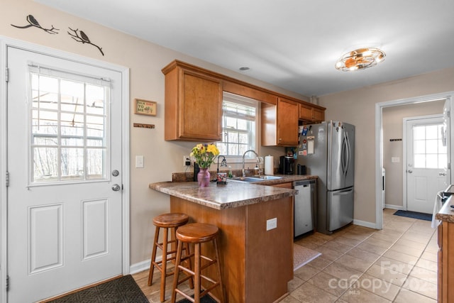 kitchen with a healthy amount of sunlight, stainless steel appliances, a breakfast bar, and sink