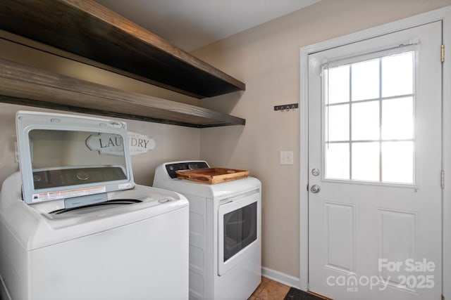 laundry area featuring tile patterned floors, washer and dryer, and a healthy amount of sunlight