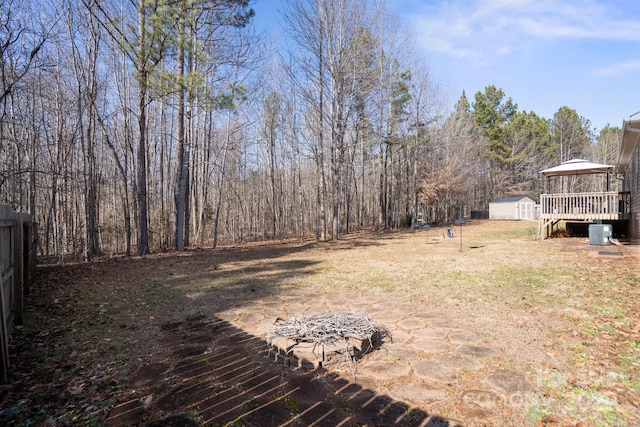 view of yard featuring a gazebo, a storage unit, and central AC unit