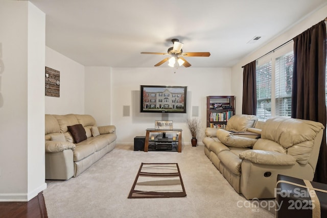 carpeted living area featuring baseboards, visible vents, and a ceiling fan