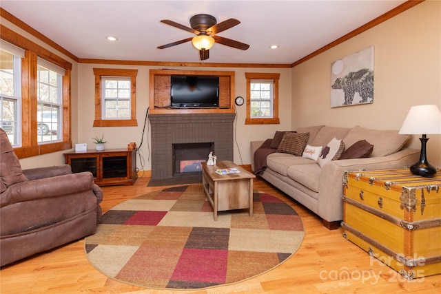 living room with hardwood / wood-style floors, ornamental molding, and a healthy amount of sunlight