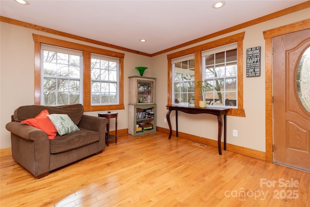 sitting room featuring ornamental molding, light hardwood / wood-style floors, and a healthy amount of sunlight