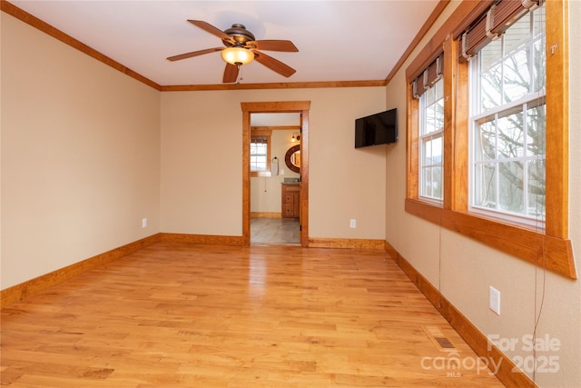 empty room featuring ornamental molding, ceiling fan, and light wood-type flooring