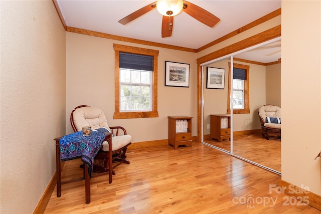 living area featuring ornamental molding, a wealth of natural light, ceiling fan, and light hardwood / wood-style floors