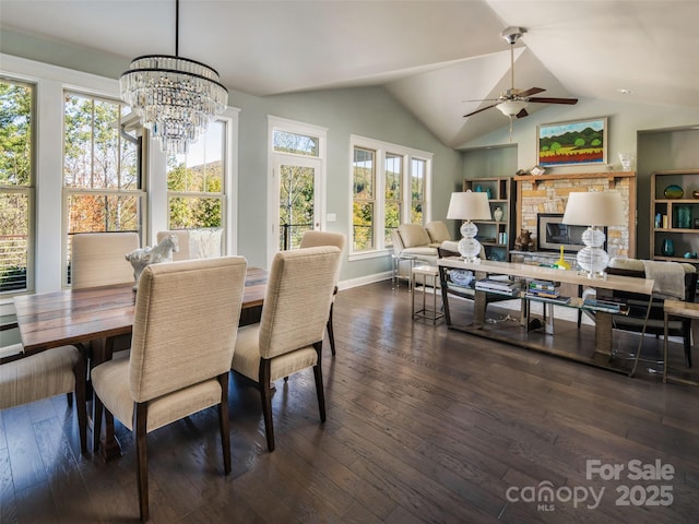 dining space with lofted ceiling, ceiling fan with notable chandelier, and dark hardwood / wood-style floors