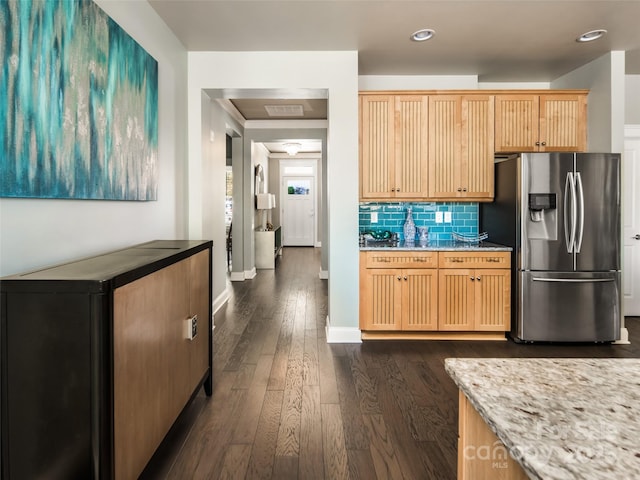 kitchen with dark hardwood / wood-style floors, light brown cabinetry, backsplash, stainless steel fridge with ice dispenser, and light stone countertops