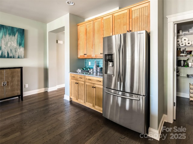 kitchen featuring light brown cabinetry, stainless steel fridge with ice dispenser, backsplash, and dark hardwood / wood-style flooring