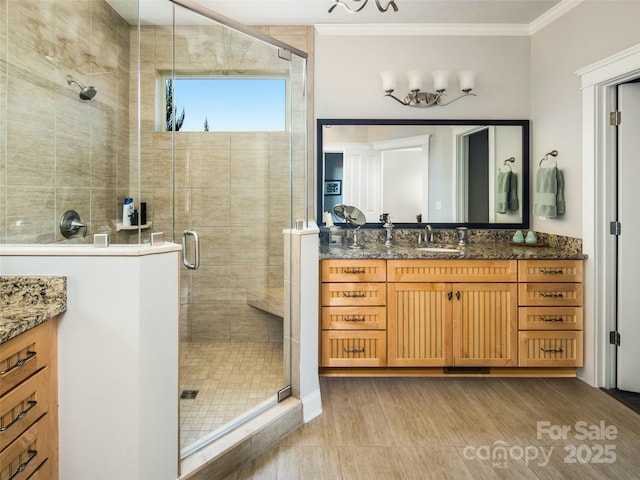 bathroom featuring vanity, crown molding, and a shower with shower door