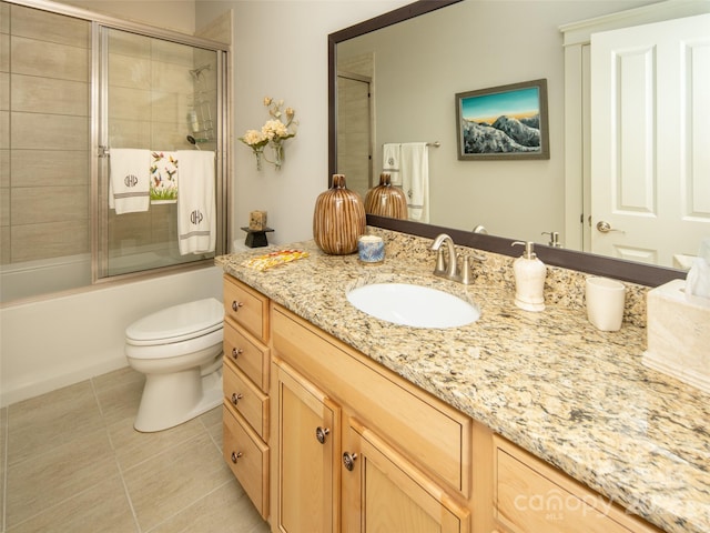 full bathroom with tile patterned flooring, vanity, shower / bath combination with glass door, and toilet