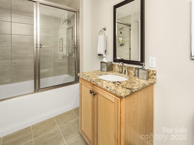 bathroom with tile patterned floors, shower / bath combination with glass door, and vanity