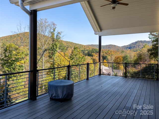 wooden deck with a mountain view and ceiling fan