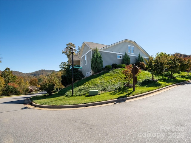 view of home's exterior featuring a mountain view and a lawn